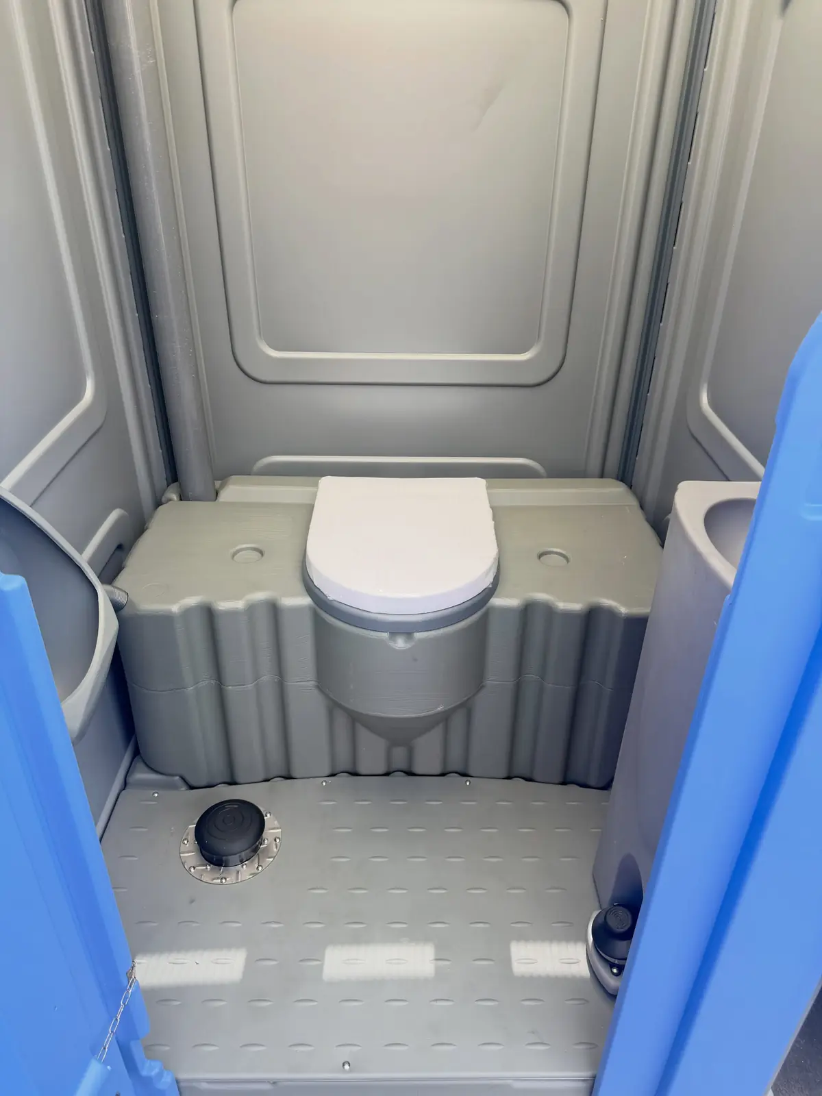 Flushing portable toilet interior with white seat