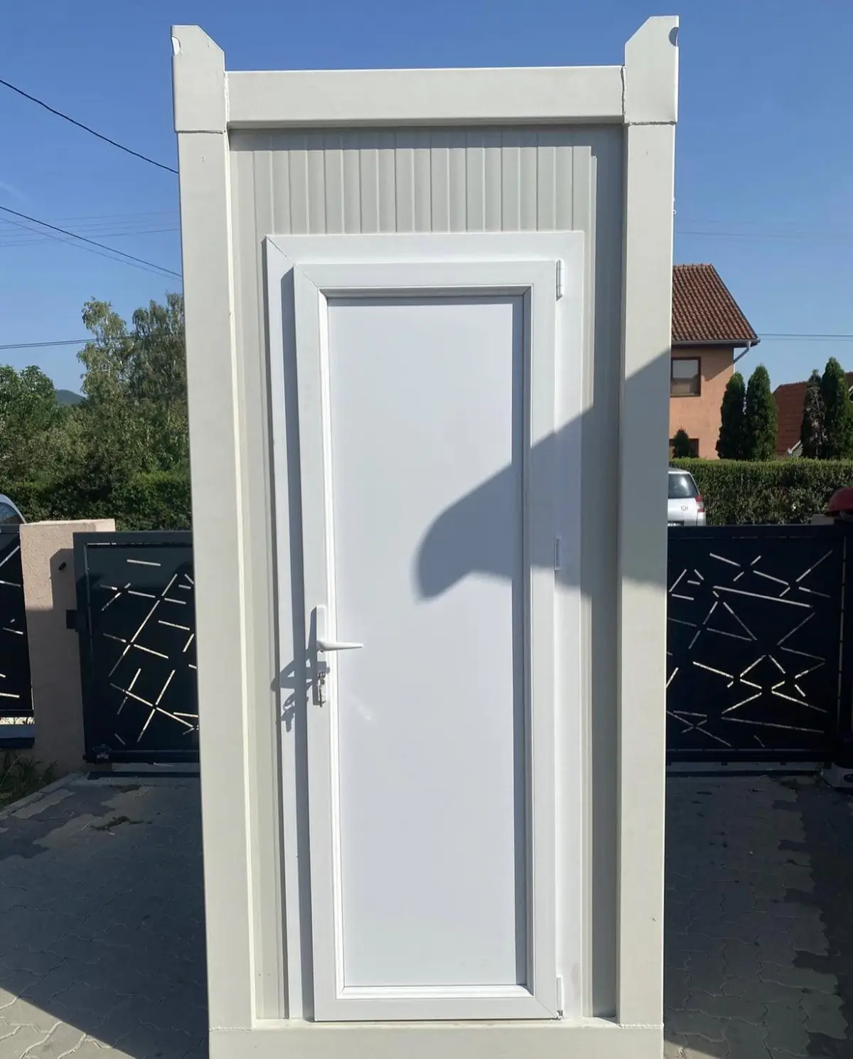 White flushing restroom cabin outside a home
