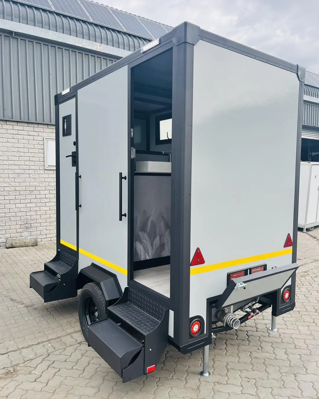 Restroom trailer with door open showing a clean stall